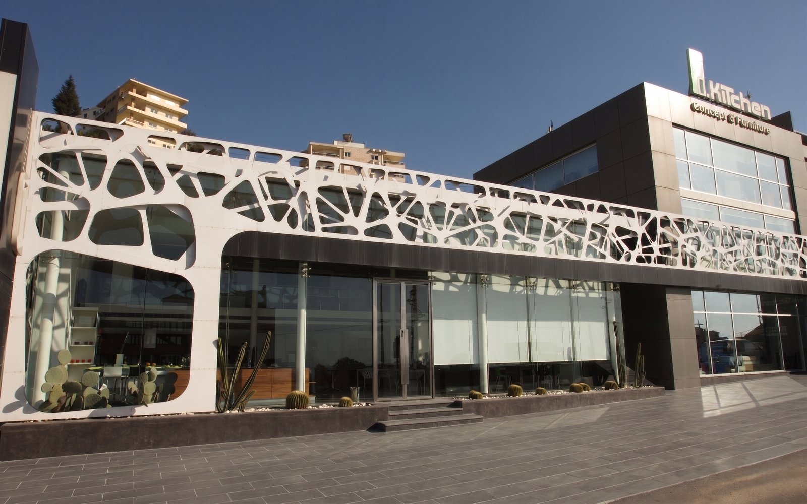 d. Kitchen showroom exterior with distinctive organic white lattice facade and floor-to-ceiling glass